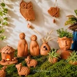 Terracotta owl, house and figures on moss